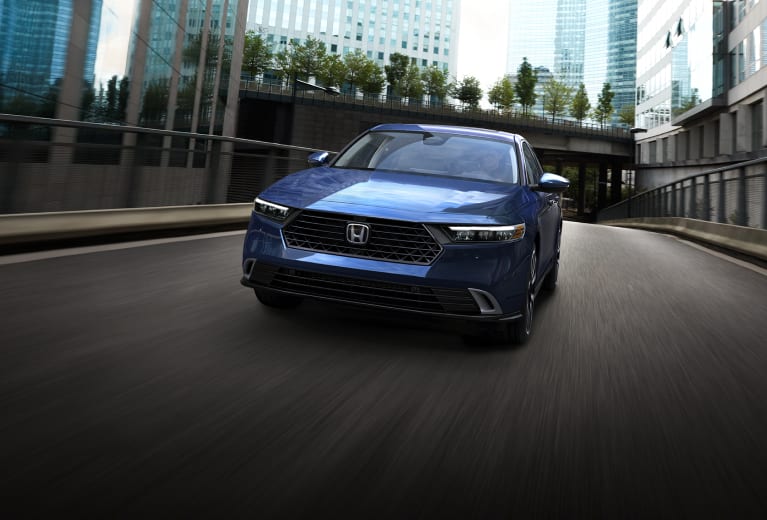 Un Honda Accord en Canyon River Blue Metallic conduciendo por un camino urbano